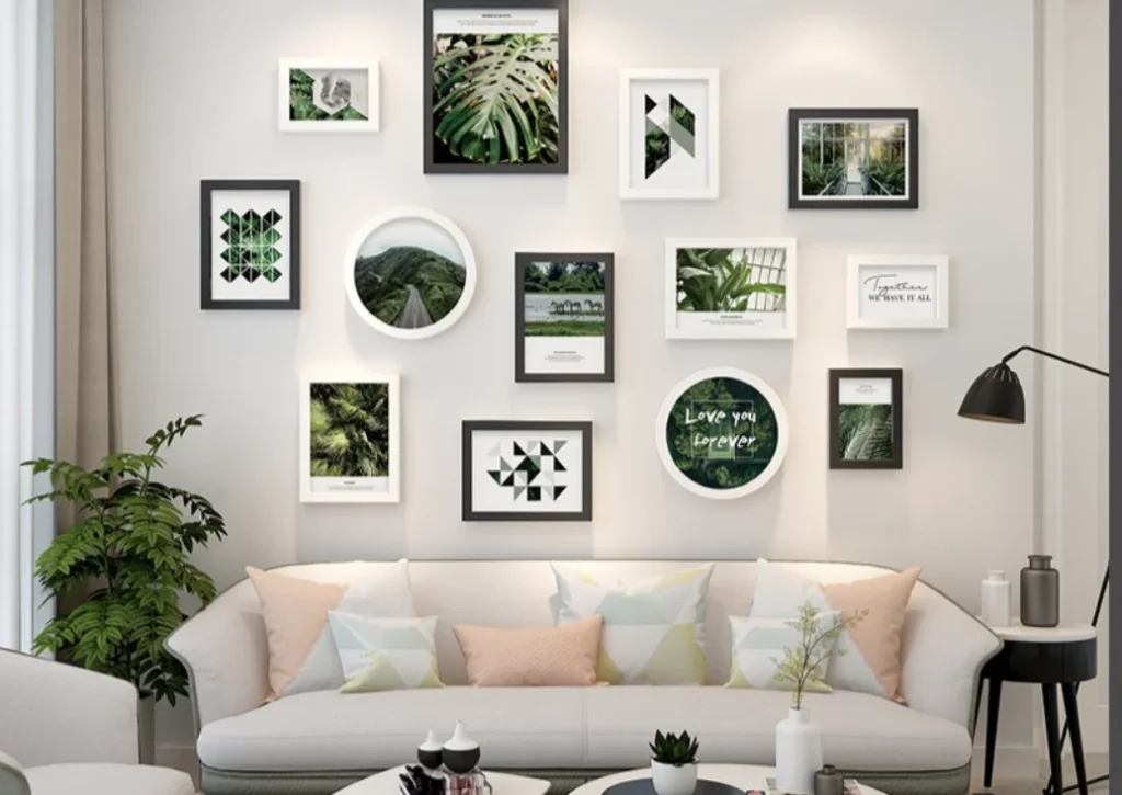 A stylish living room with a collection of black and white photo frames featuring greenery artwork and geometric designs on a beige wall, above a white sofa.
