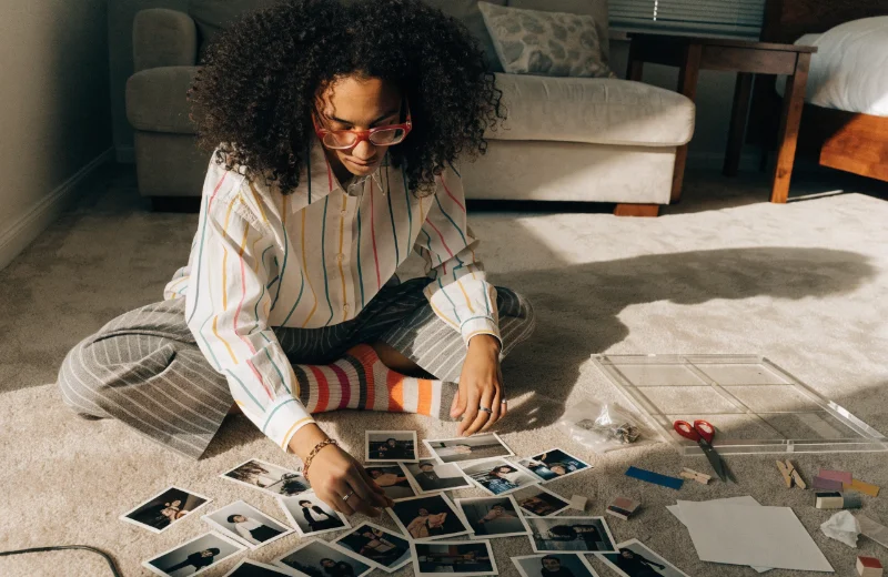 Arranging Photos in a Collage Frame A person arranging photos on the floor before putting them in a collage frame