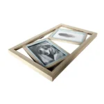 Natural wooden collage picture frame with two compartments, displaying a photo of a dog and an image of a feather, isolated on white.