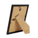 A back view of a black photo frame with a foldable support stand and wall-mounting hooks, showcasing its versatile design.