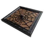 Square black photo frame with intricate lace design and a decorative beetle accent in the center, resting on a light background.