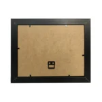 Backside of a black photo frame showing MDF board, metal clips, and a mounting hook for wall hanging.