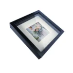 A sleek black shadow box photo frame featuring a matted image of a floral bouquet, elegantly displayed on a white background.