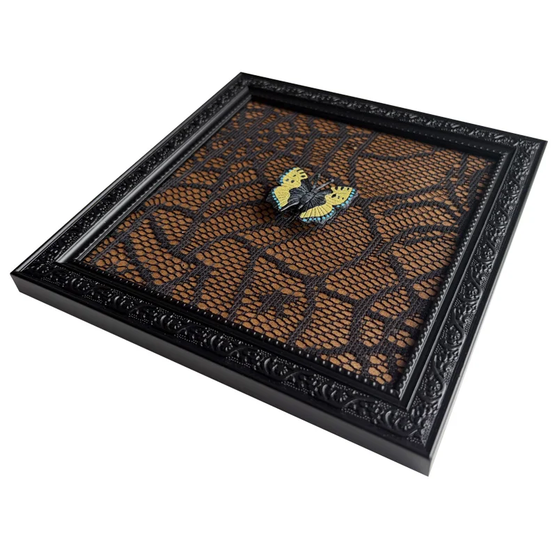 Black decorative photo frame with intricate details featuring a yellow butterfly placed on a black lace-patterned background.