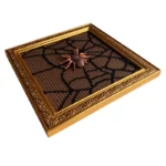 Ornate gold frame displaying a black mesh web design with a small realistic spider decoration in the center.