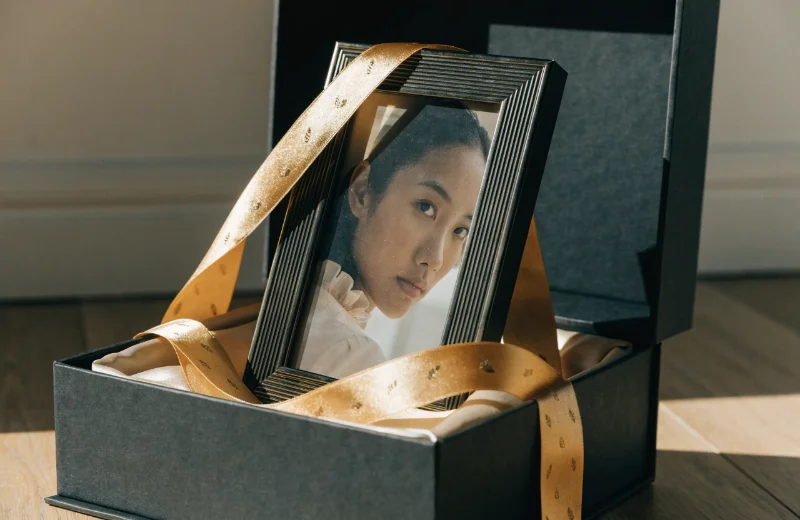 Premium Gift Photo Frame Market A beautifully wrapped photo frame next to a gift box and ribbon.