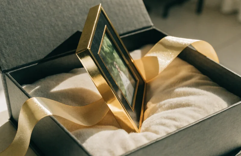 Premium Photo Frame Packaging An elegant photo frame sitting inside a high-quality gift box with a silk ribbon.