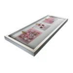 A sleek shadow box picture frame with multiple pink inserts, showcasing various jewelry pieces like earrings and pendants.