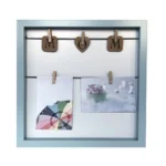 Decorative pastel blue photo frame with a string, wooden clips spelling 'MOM,' and two clipped pictures.