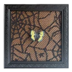 A decorative black photo frame with intricate designs featuring a lace-patterned background and a yellow and black butterfly.