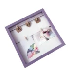 Purple square photo frame with black strings and wooden clips showcasing the word 'MOM' and two photos, ideal for home décor.