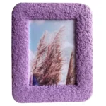 Purple textured photo frame with a soft, fluffy surface and an image of ornamental grass against a blue sky.