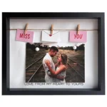 Black photo frame displaying a couple embracing on railroad tracks with 'Miss You' decorations and 'Love from my heart to yours' text.