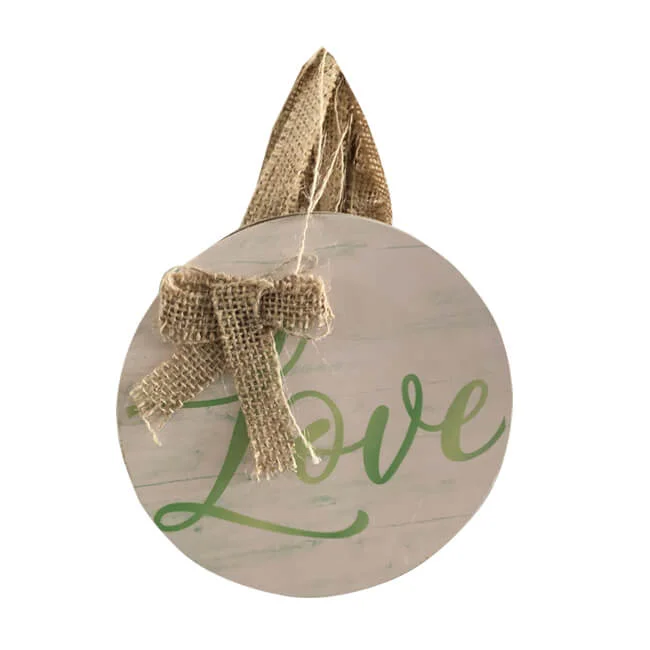 Round rustic hanging sign with 'Love' written in green and decorated with a burlap bow and twine loop for hanging.