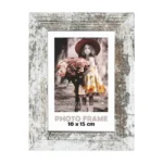 Rustic wooden photo frame with distressed white finish surrounding a 10x15 cm photo of a girl holding a bouquet of roses outdoors.