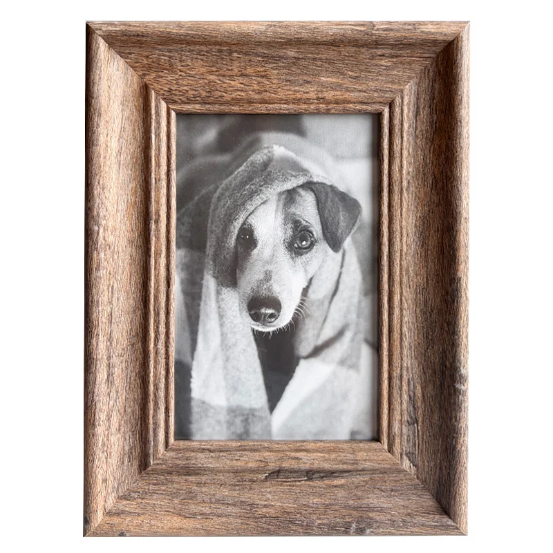 A rustic-style wooden photo frame showcasing a black-and-white photo of a dog wrapped in a blanket, conveying warmth and charm.