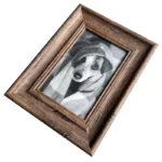 Rustic wooden photo frame showing a black-and-white portrait of a dog wrapped in a blanket.