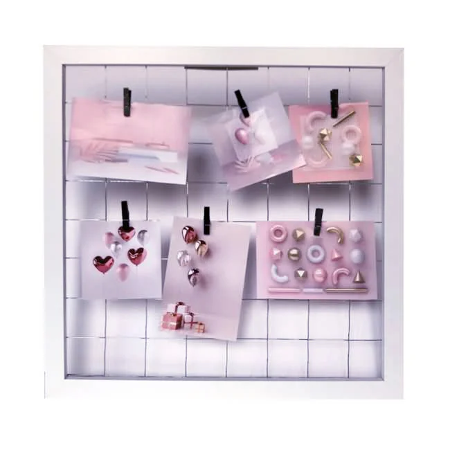 White grid display frame with pink decor cards and clips for a chic, organized presentation. Ideal for photos or wall art.