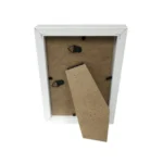 Rear view of a white photo frame with a removable back panel, metal clips, and an easel stand for tabletop display.