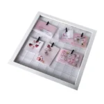 White square photo frame featuring a wire grid with clipped decorative cards in pastel pink tones and small items.