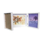 White tri-fold photo frame displaying inspirational prints with autumn leaves and winter tree design, one section empty.