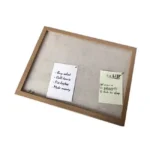 Wooden pinboard with a natural frame and two pinned notes on a beige background.