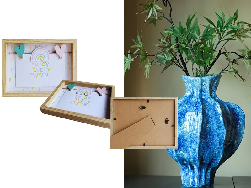 Wooden photo frame with heart-shaped clips and rainbow design alongside a vibrant blue ceramic vase with green branches.