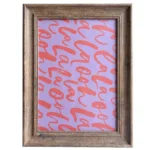 Rustic wooden photo frame with a vibrant purple background featuring red calligraphy text pattern.