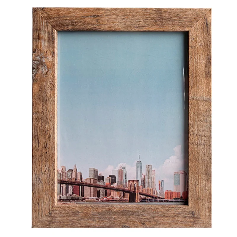 Rustic wooden photo frame holding a cityscape print featuring a skyline and bridge under a clear sky.