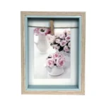 Light wood photo frame with inner blue edge, showcasing a floral image held by a twine and small clip.