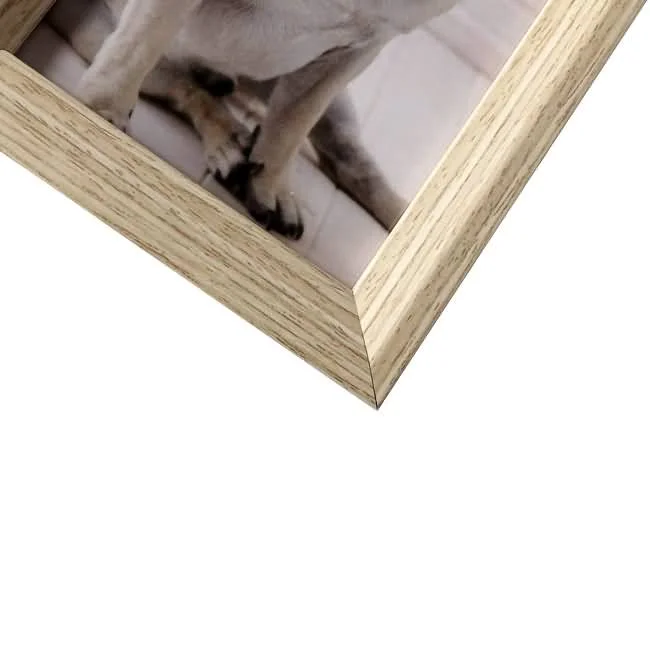 Close-up view of a wooden photo frame corner with light wood grain texture and a photo inside.