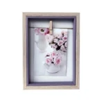 Wooden photo frame with a soft lavender inner border showcasing a floral image clipped on a string.