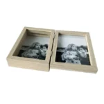 Dual wooden photo frame with hinged opening, holding black-and-white photos of a girl, placed on a white background.