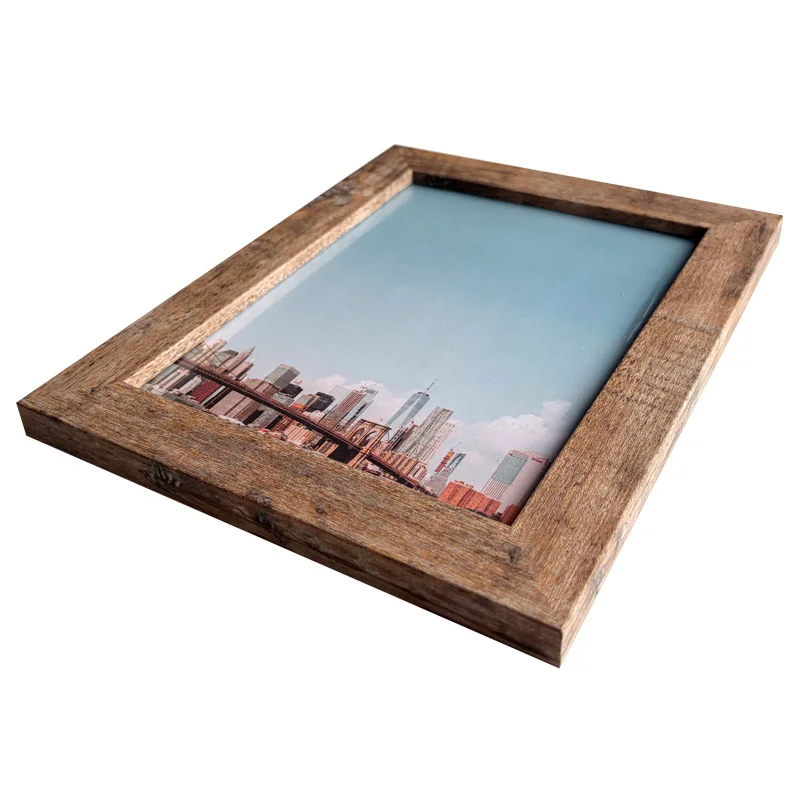 Angled view of a rustic wooden photo frame displaying a modern cityscape image against a light blue background.