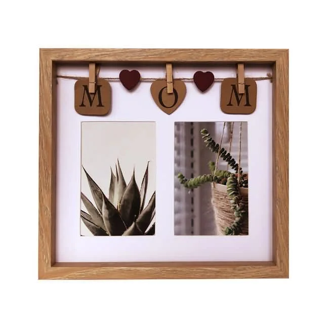 A wooden photo frame featuring the word 'MOM' with hanging heart and letter decorations, holding two photos of plants.