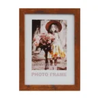 Rustic brown wooden photo frame displaying a sepia-toned portrait of a girl holding flowers, placed against a white background.