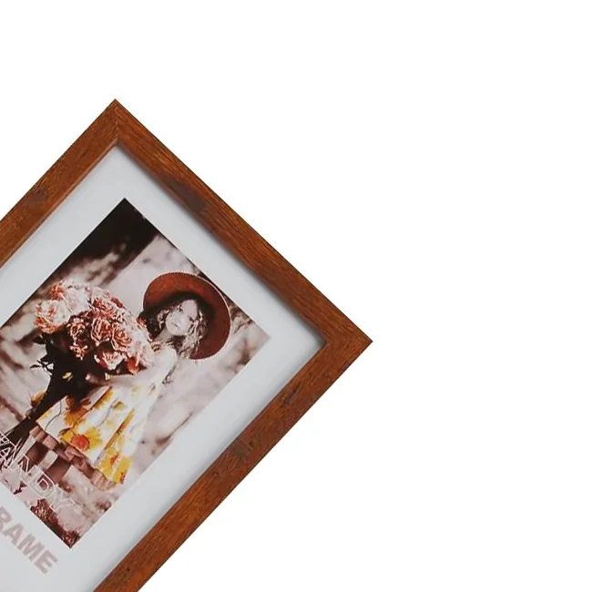 A rectangular wooden photo frame displaying a sepia-toned portrait of a girl holding flowers, wearing a wide-brimmed hat.