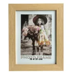 A decorative wooden photo frame with a 15x21 cm photo of a young girl in a floral dress holding a bouquet of flowers.