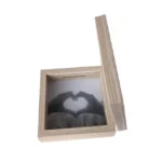 Wooden photo frame box with a natural finish featuring a removable lid and a slot for inserting photos. The displayed image shows hands forming a heart shape.