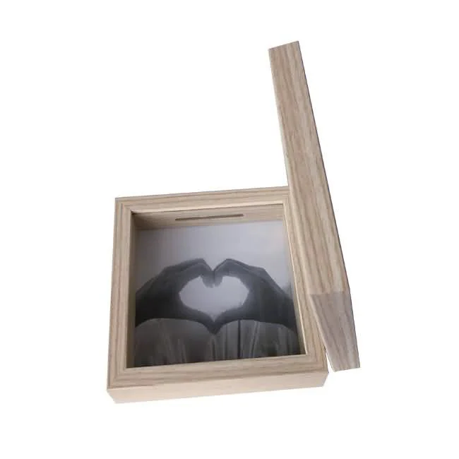 Wooden photo frame box with a natural finish featuring a removable lid and a slot for inserting photos. The displayed image shows hands forming a heart shape.