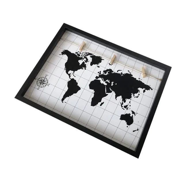 Wall-mounted photo display frame with black border, world map design on a white grid background, and four wooden clips.