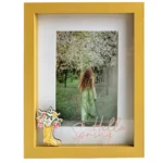 Yellow photo frame with a decorative spring motif, featuring a nature photo of a woman in a green dress in a blossoming orchard.