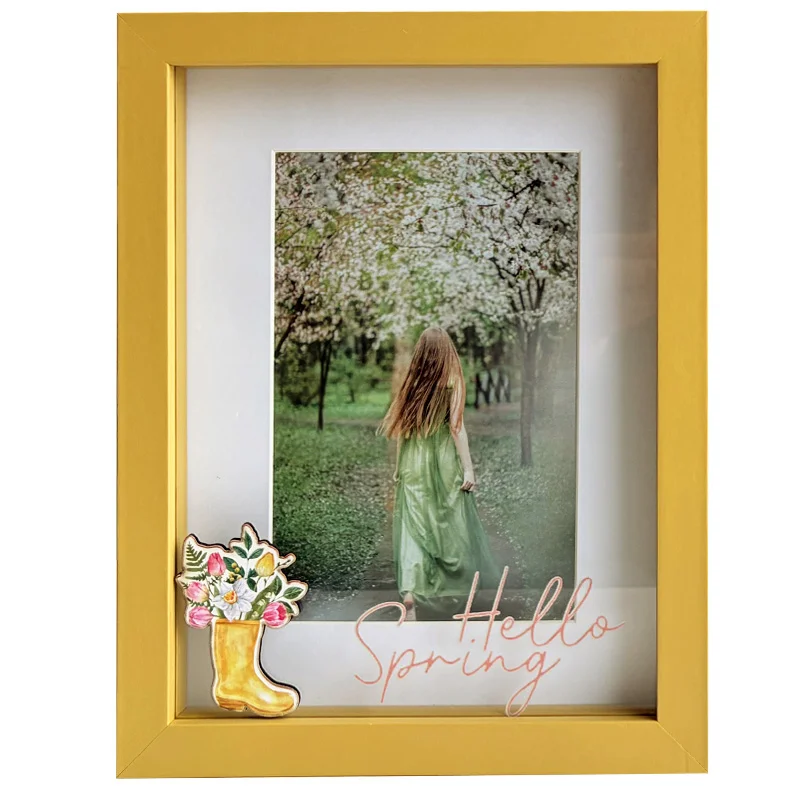 Yellow photo frame with a decorative spring motif, featuring a nature photo of a woman in a green dress in a blossoming orchard.